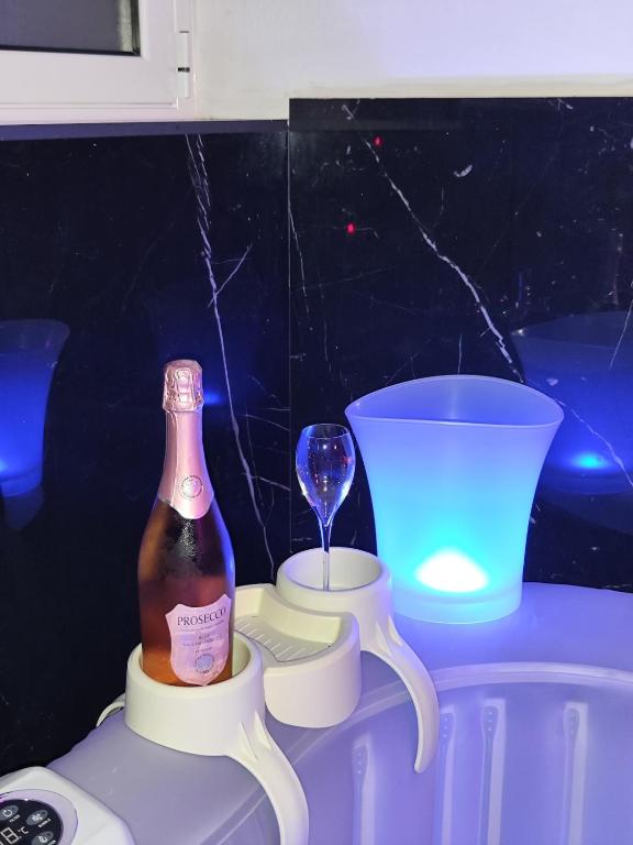 a bottle of champagne and a wine glass on a table at Magic House in Palermo