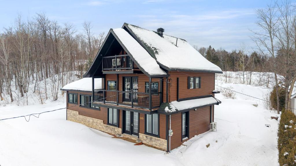 a wooden house with snow on the roof at Évadez-vous à Grandes-Piles in Grandes-Piles