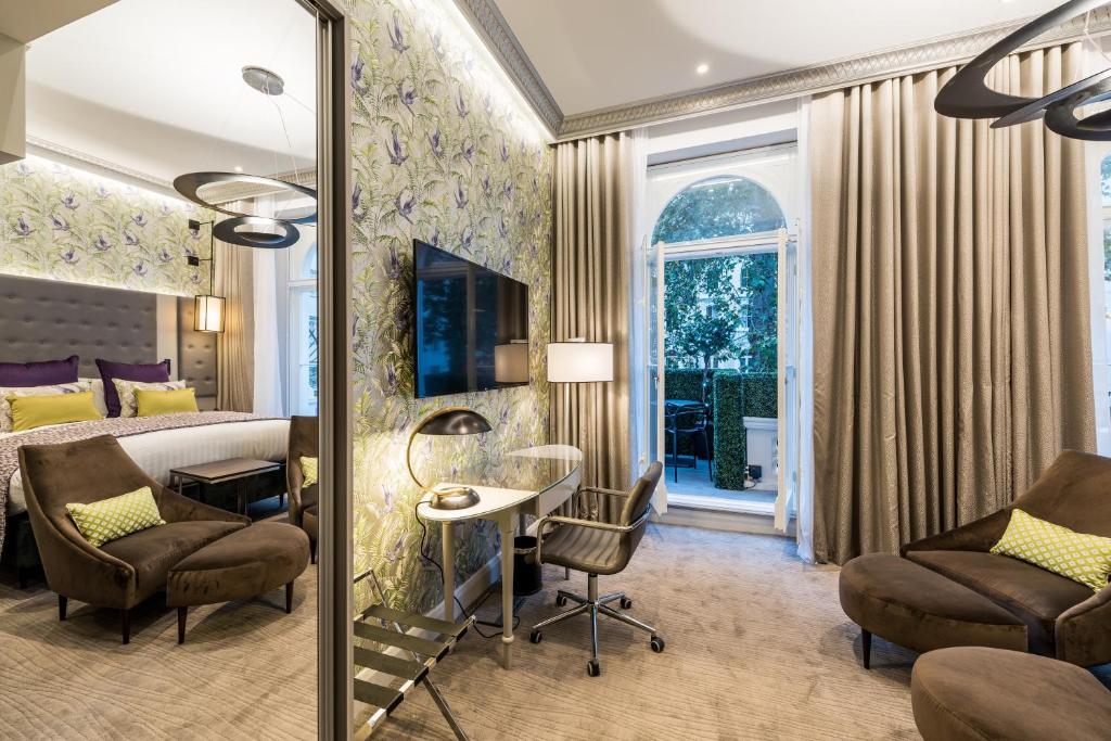 Cette chambre comprend un lit, un bureau et des chaises. dans l'établissement Mercure London Hyde Park Hotel, à Londres