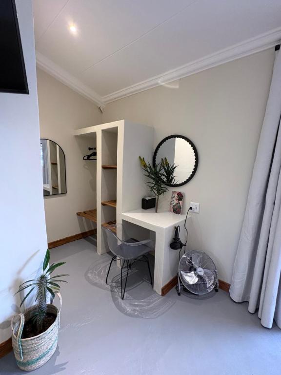 a room with a desk and a mirror and a chair at Haze Inn Cottages Crowned in Henburg Park