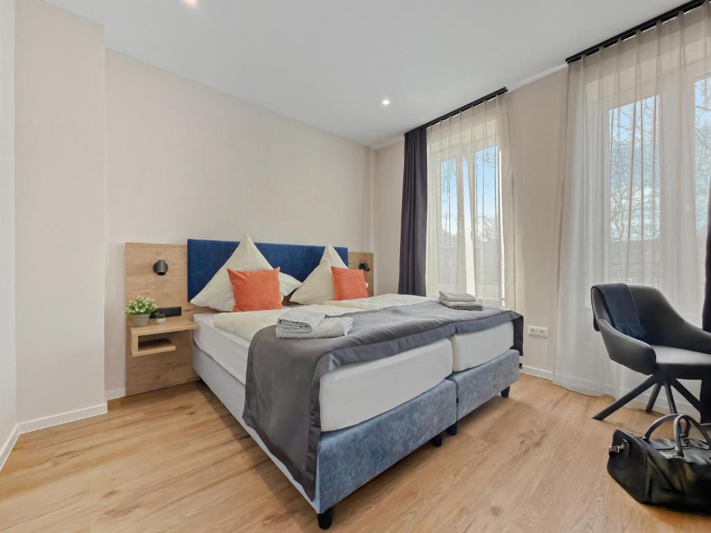 a bedroom with a large bed and a chair at City Pension Heide in Heide