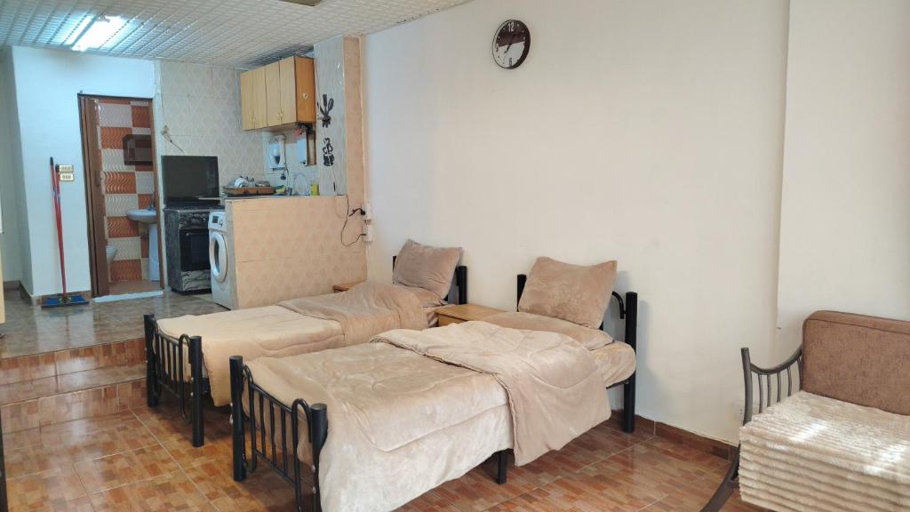 a living room with two beds and a kitchen at بيت الحجر 2 in Amman