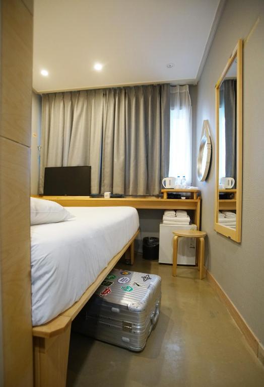a bedroom with a bed and a suitcase on the floor at Hotel Dada Gyeongbokgung in Seoul