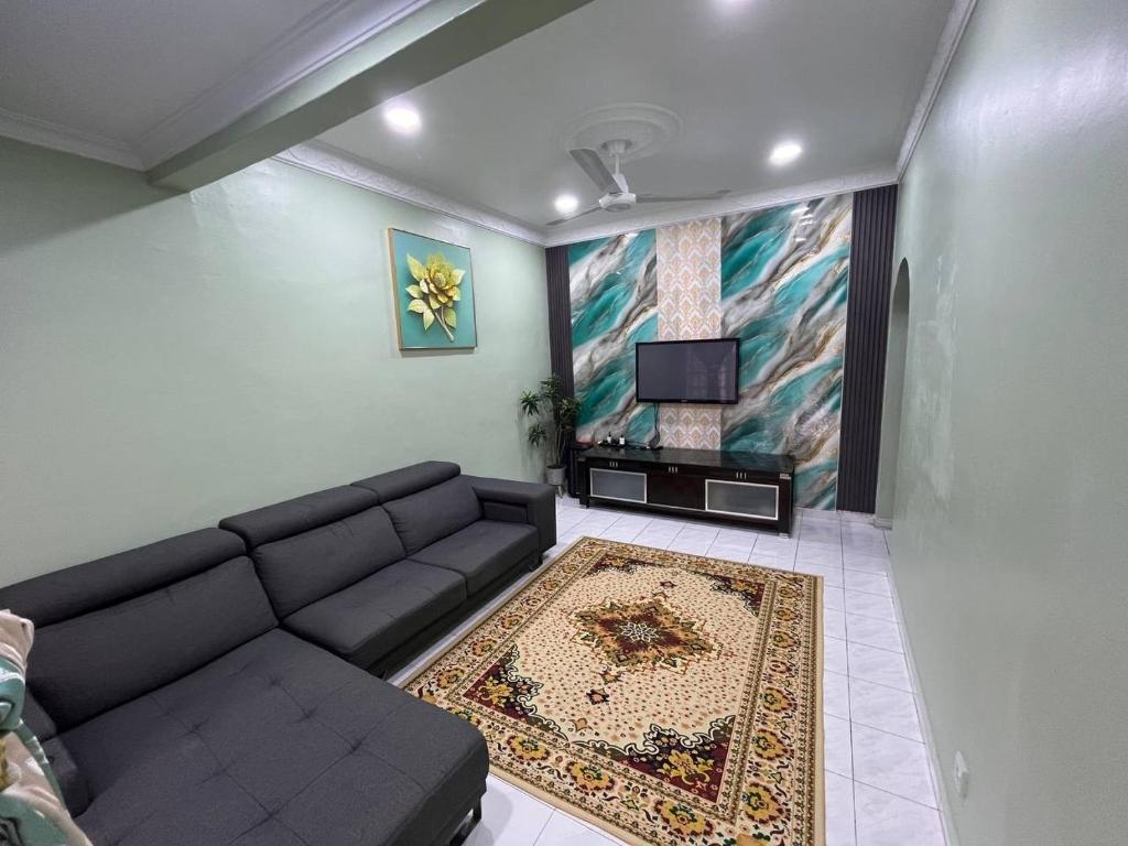 a living room with a couch and a flat screen tv at Teratak Embah in Nilai
