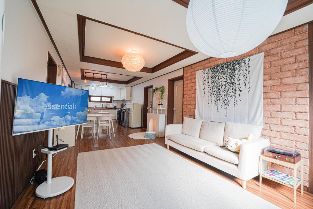 a living room with a couch and a tv at Traditional Korean houses Stay Yeon in Busan