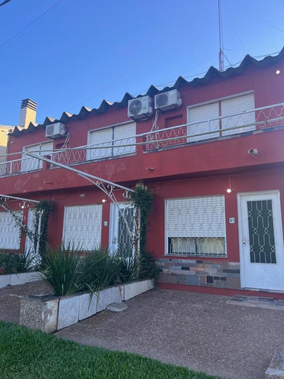 a red house with two balconies on it at Azahares in Termas del Daymán