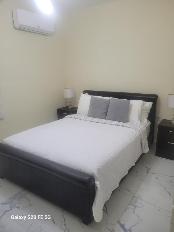 a bedroom with a large bed with white sheets and pillows at " Bienvenido a casa " in San Pedro de Macorís
