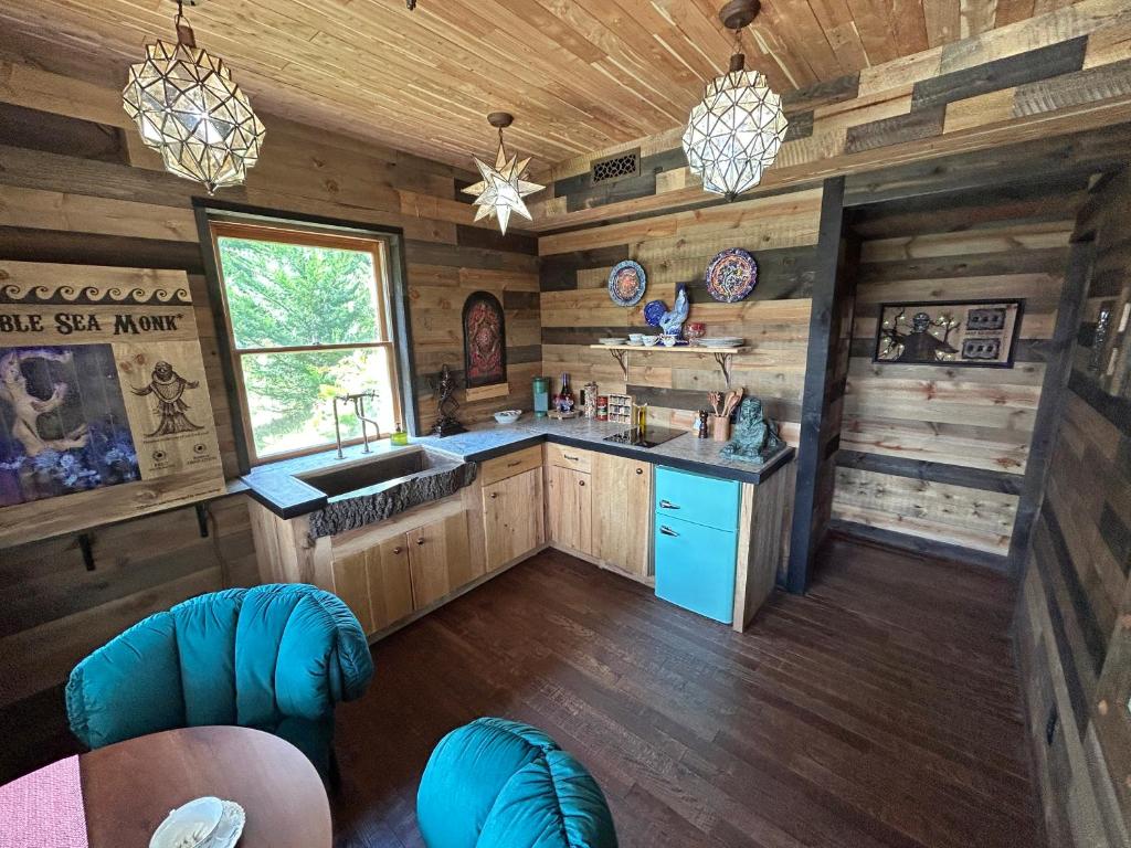 a kitchen in a cabin with wooden walls and a sink at Luminary Lodge in Sevierville