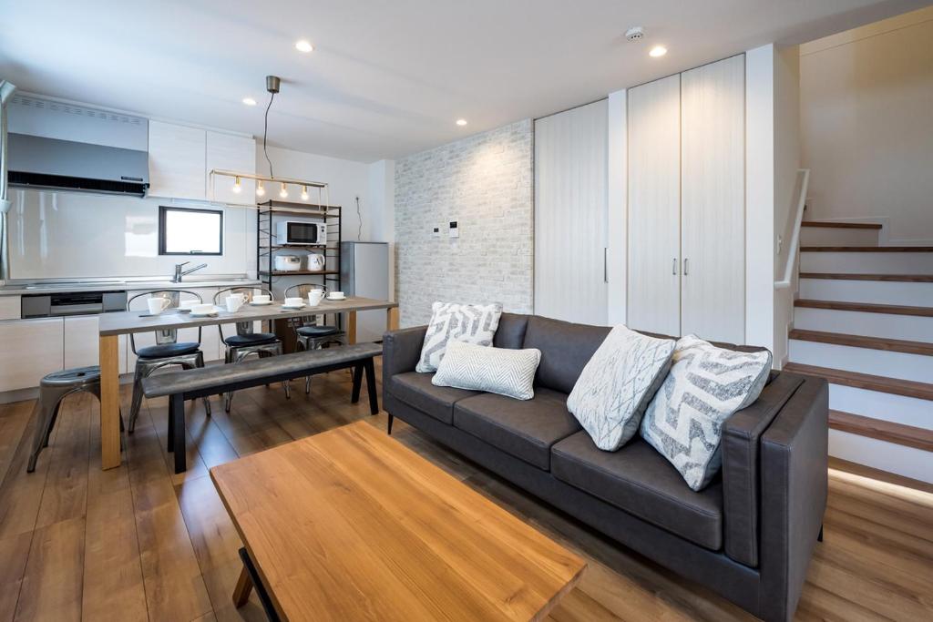 a living room with a couch and a dining room at Aile Hose Ⅱ in Takasaki
