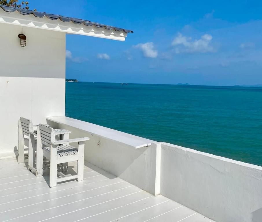 two chairs sitting on a porch overlooking the ocean at Peaceful Hideaway with Stunning View Beach Access in Mae Nam