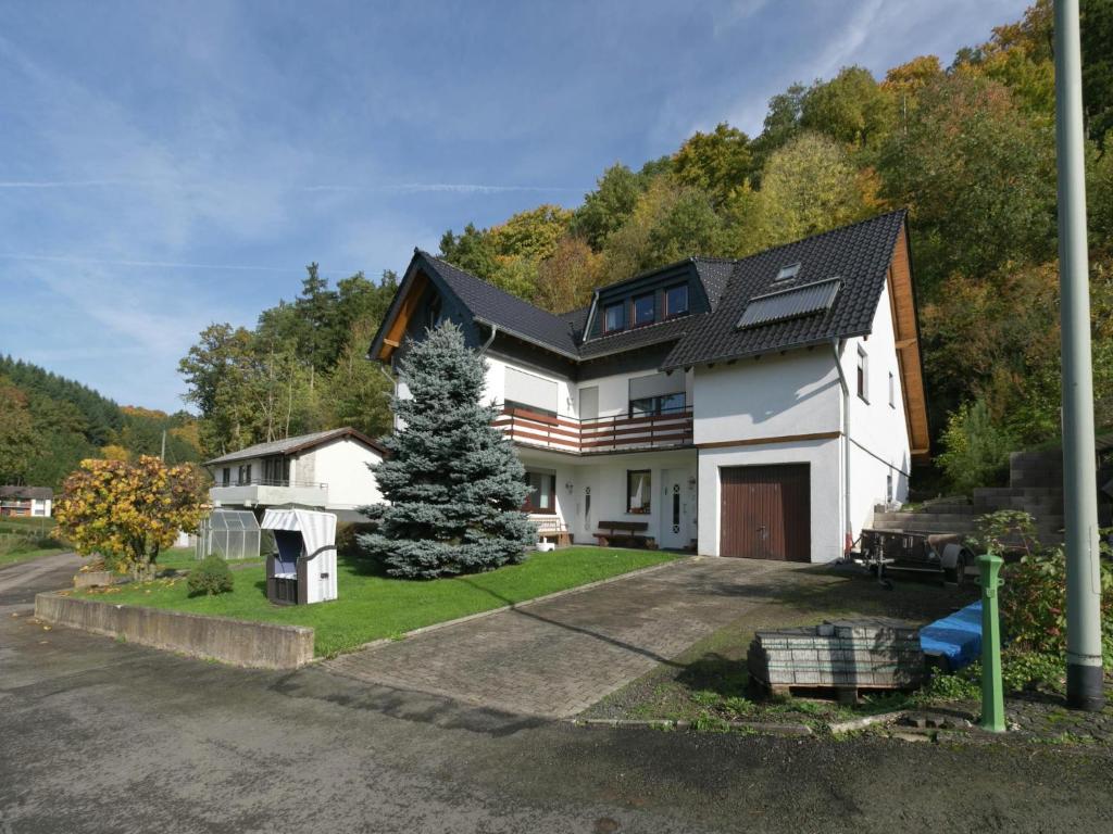 a white house with a christmas tree in the yard at Ferienwohnung in der Vulkaneifel in Winkel