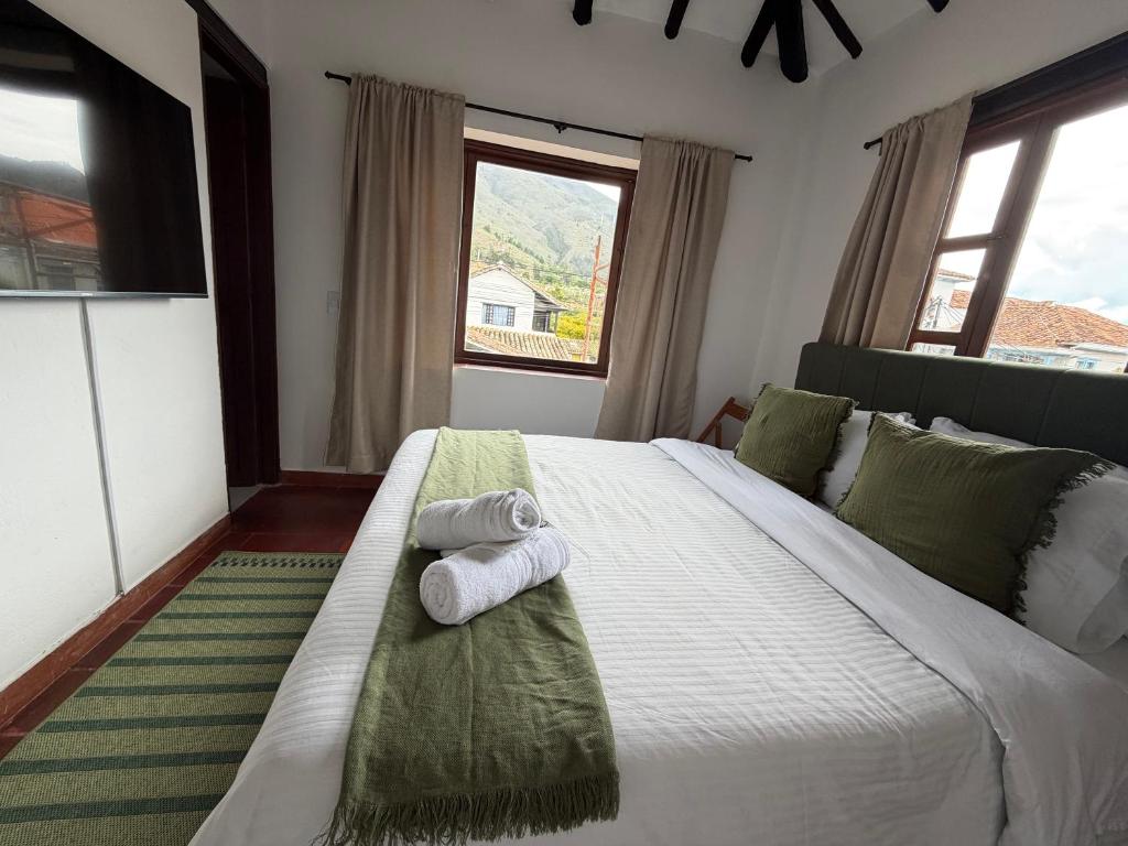 a bedroom with a large bed with towels on it at Hostel Once Once in Villa de Leyva
