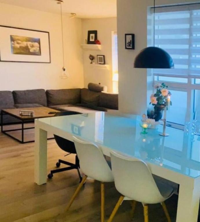 a dining table and chairs in a living room at Friggjarbrunnur shared home in Reykjavík