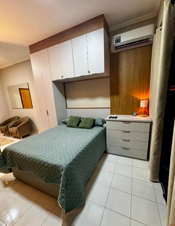 a bedroom with a bed and a dresser in it at Apê Moderno in Caxambu