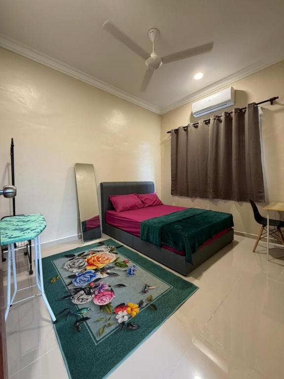 a bedroom with a bed and a rug with flowers on it at Teratak Bonda in Temuh