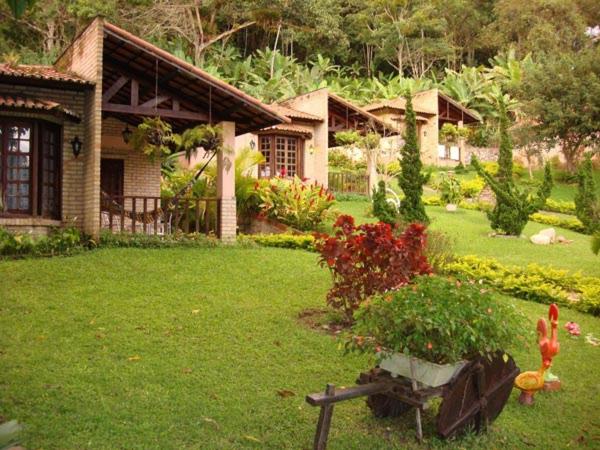 a house with a yard with a house with a garden at Pousada Chale Cana Brava in Guaramiranga