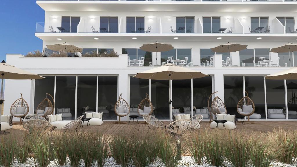 a hotel with chairs and tables and umbrellas at Paradise Resort Evia, a member of Radisson Individuals in Eretria