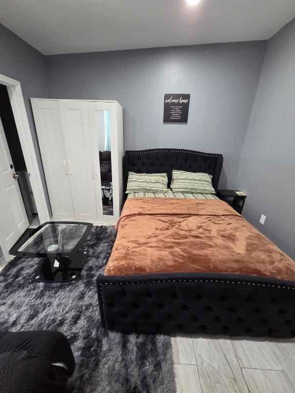 a bedroom with a large bed and a glass table at Queen Detached Studio 1 in Irvington