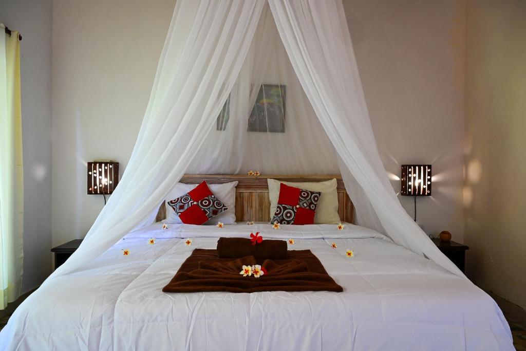 a bedroom with a bed with a canopy at Kubu Pertiwi Pemuteran in Pemuteran
