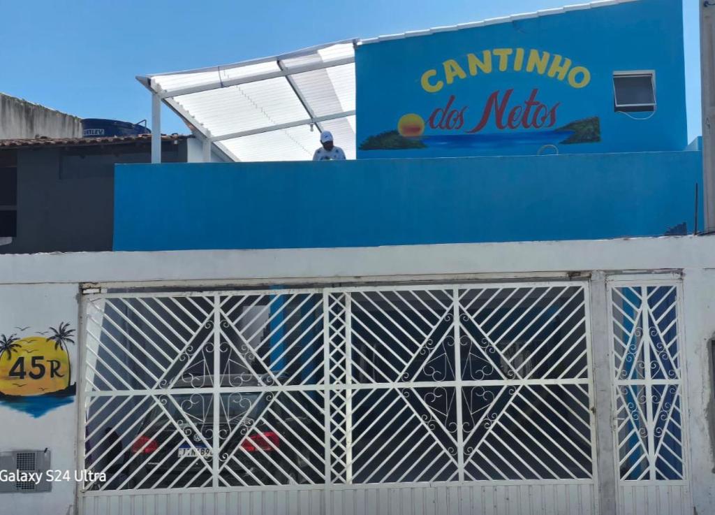 a man standing on top of a building behind a gate at Cantinho dos netos-suites próximo ao Sesc em Bertioga in Bertioga