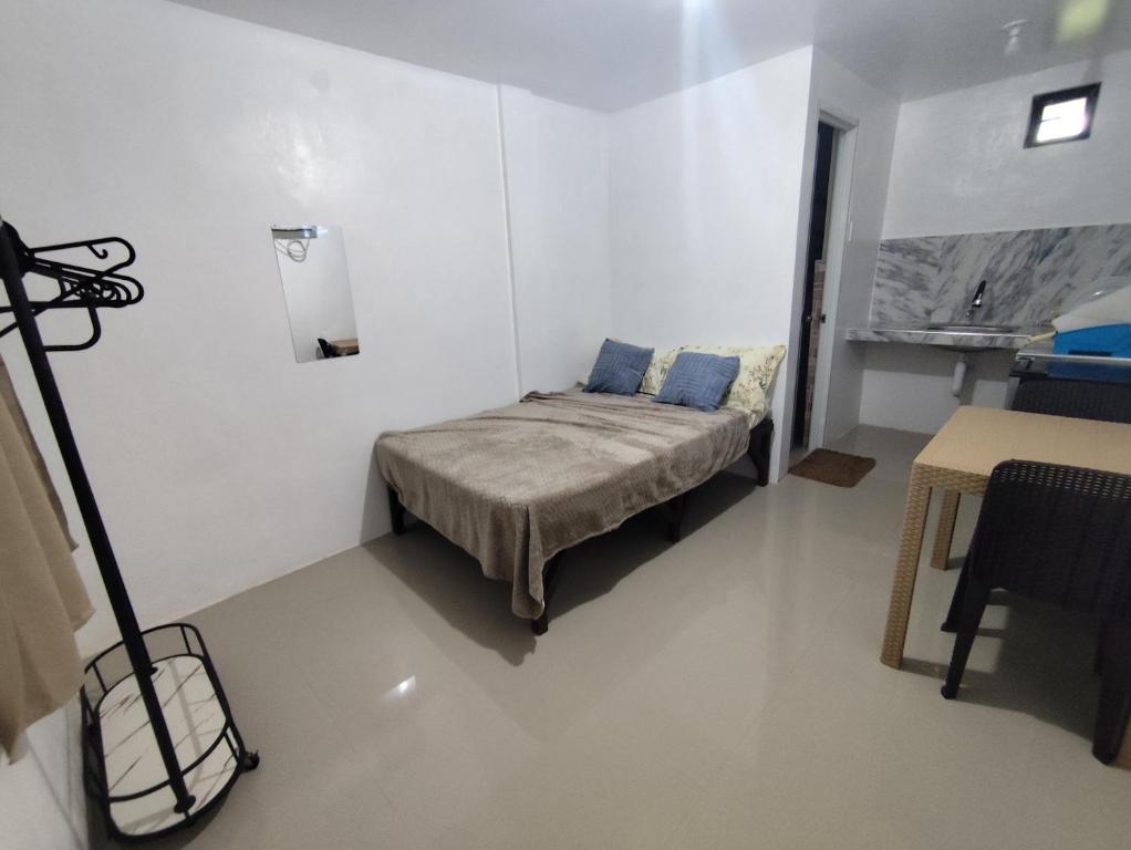a small bedroom with a bed in a white room at Lorna's Home in Panglao Island