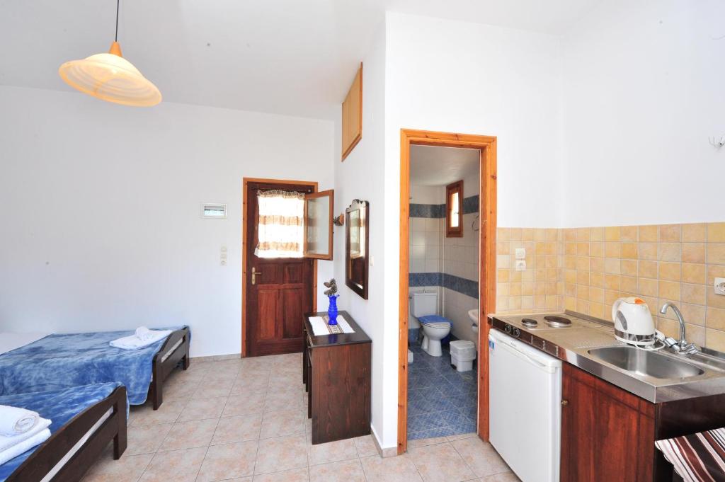 a room with a bed and a bathroom with a sink at Pension Sofia Amorgos-Katapola in Katapola