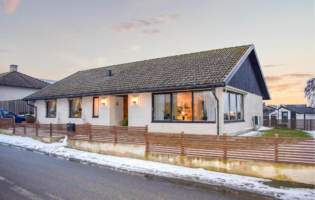 a white house with a fence on the side of the road at Beautiful Home In Simrishamn in Simrishamn