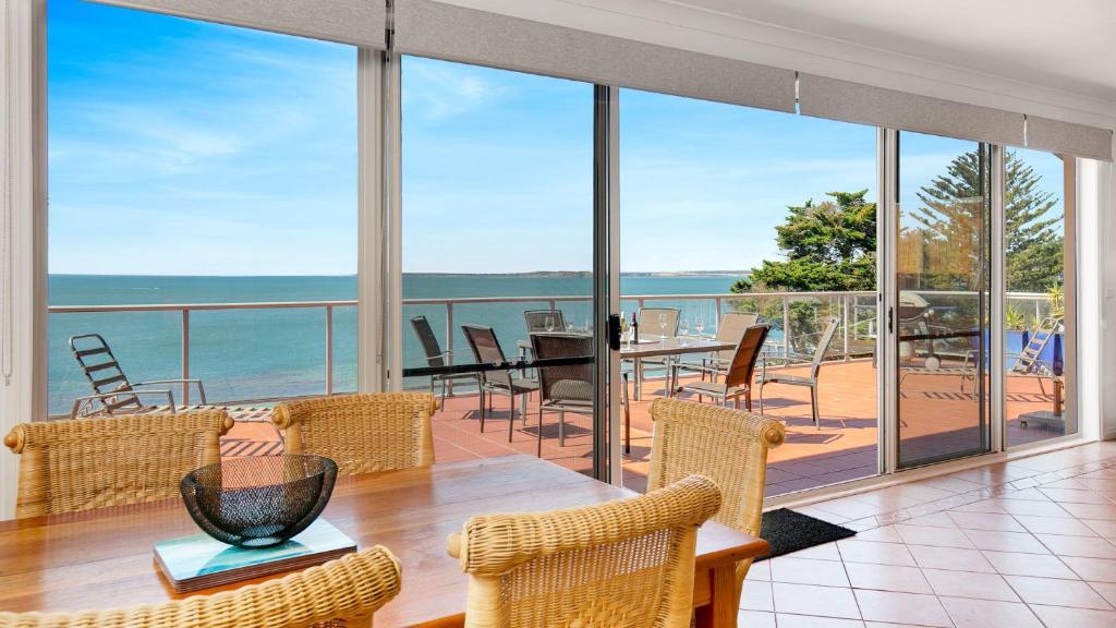 a dining room with a view of the ocean at Cowes Beachfront Penthouse in Cowes