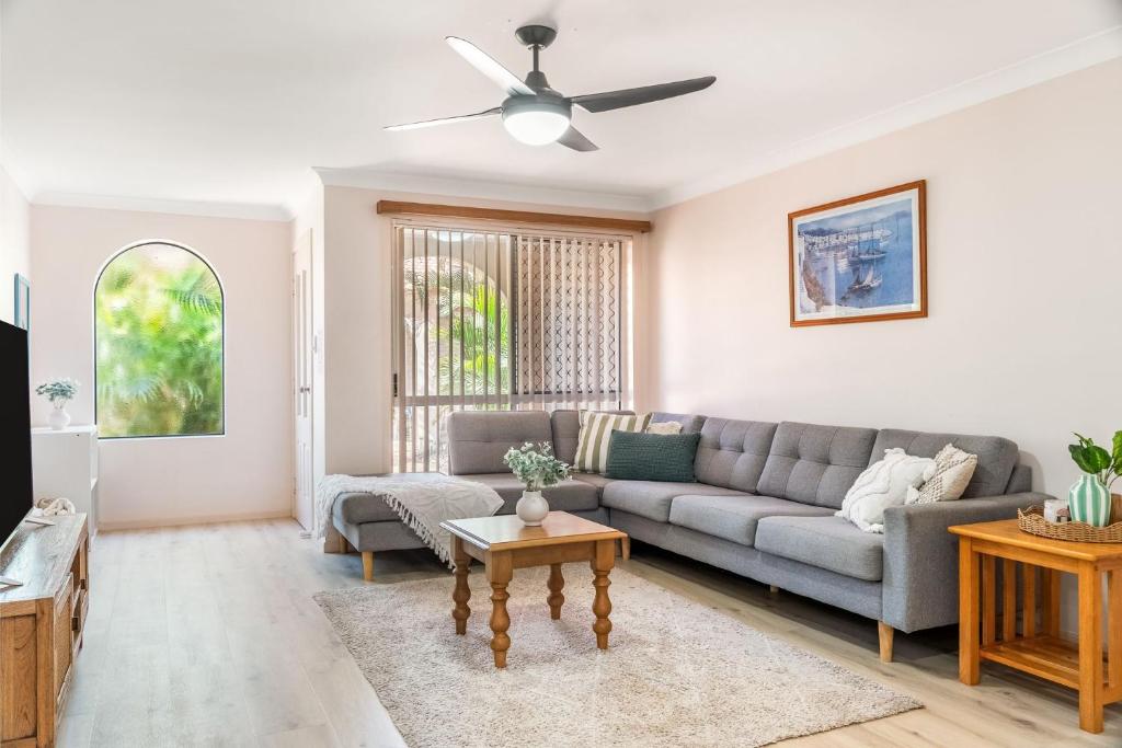 a living room with a couch and a ceiling fan at Waratah Retreat in Evans Head