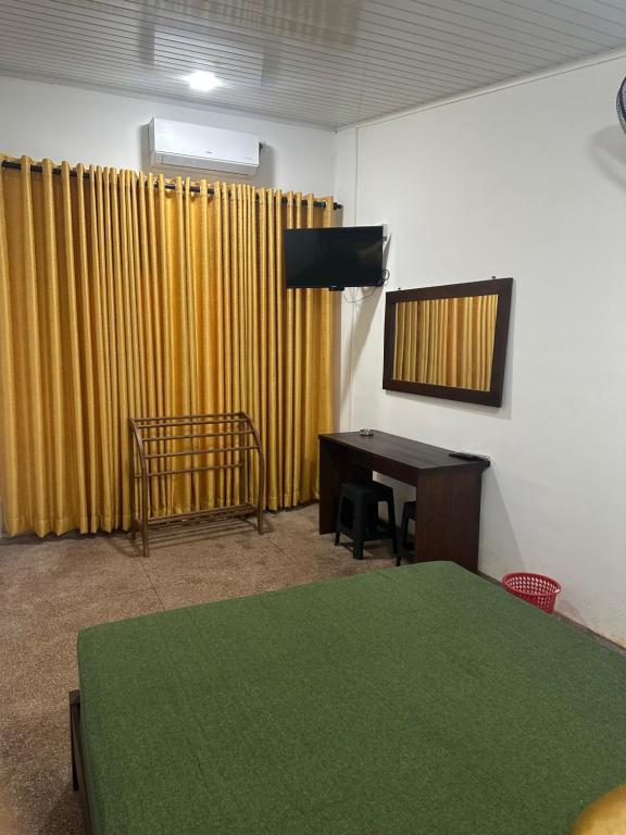 a room with a table and a television and a desk at Solace More Hotel - Borella 2 in Colombo