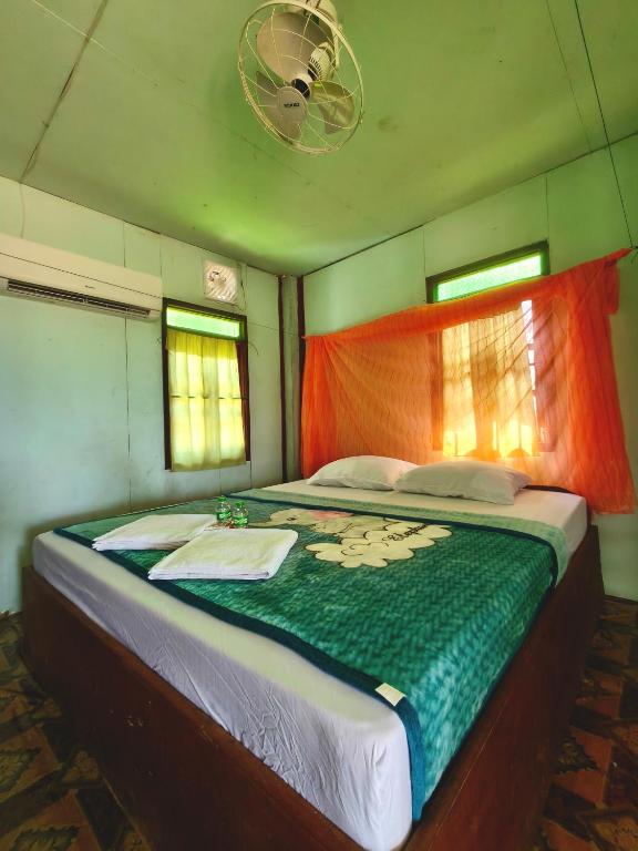 a bed in a small room with a blanket on it at Noupad sunset Guesthouse in Don Det