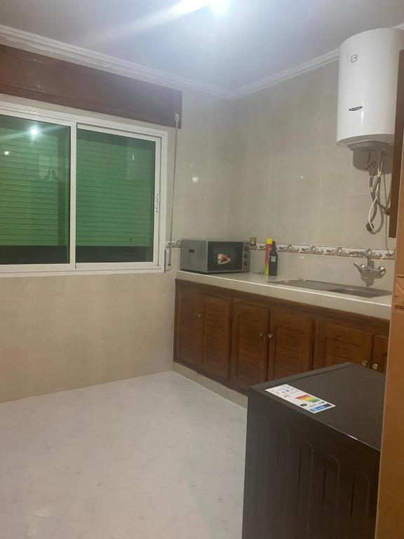 a kitchen with a sink and a window and a counter at Balcon atlantico in Larache