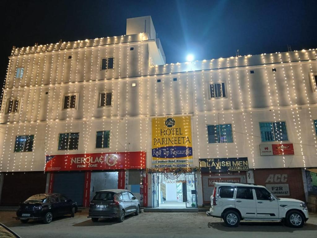 a building with cars parked in front of it at Hotel Parineeta in Khagaria