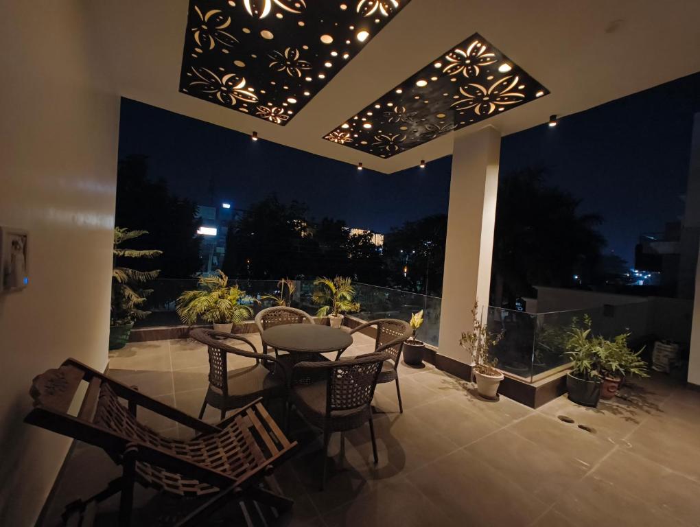 a patio with a table and chairs and lights at Calm Corner in Panchkula