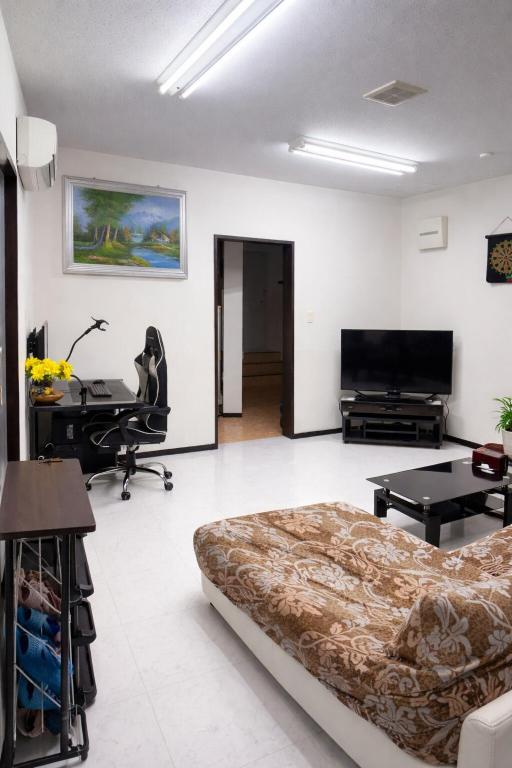 a living room with a bed and a table at Local LifeYOMITAN in Yomitan
