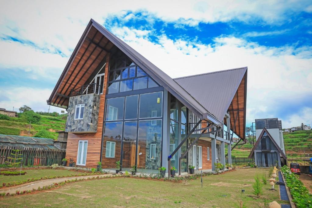 a house with a gambrel roof and glass at Stone Heaven Villa in Nuwara Eliya
