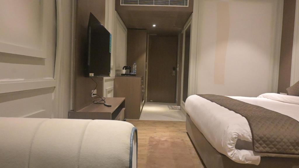 a hotel room with a bed and a television at Hotel The Grand Mirage in Bathinda