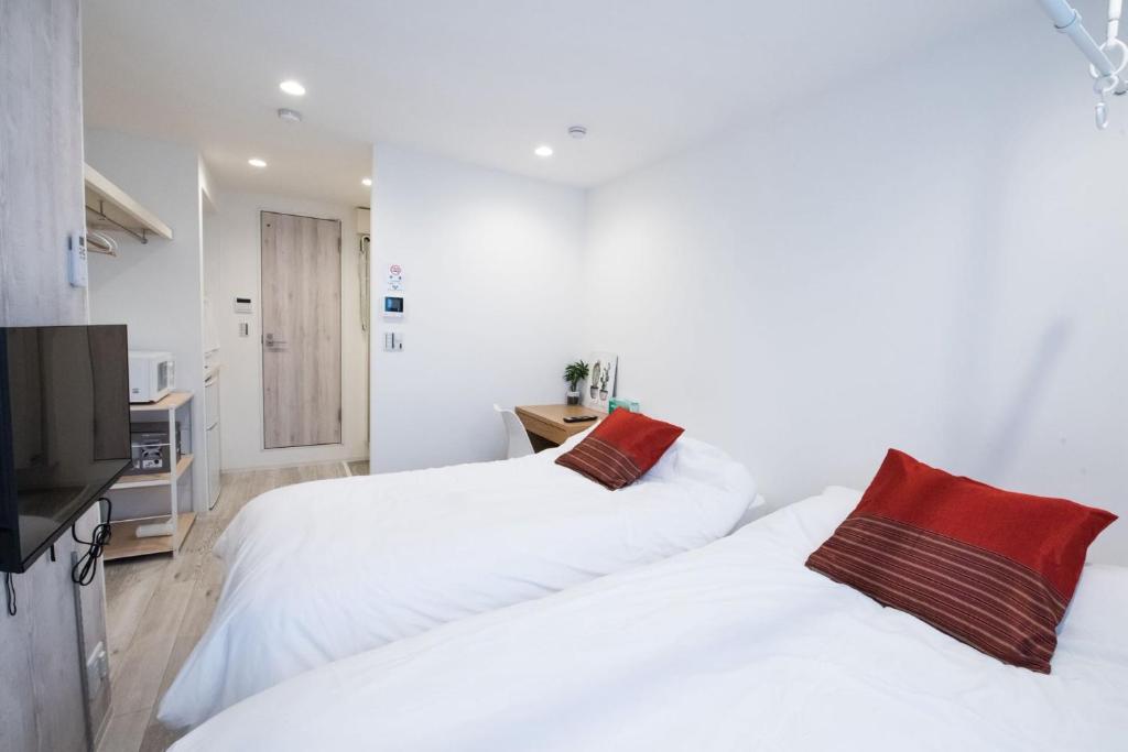 two white beds in a room with a television at Boa Sorte Hotel AD0515 in Tokyo