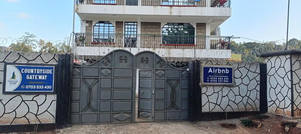 a gate in front of a house with a building at countrysidegatewayapartments in Nyeri