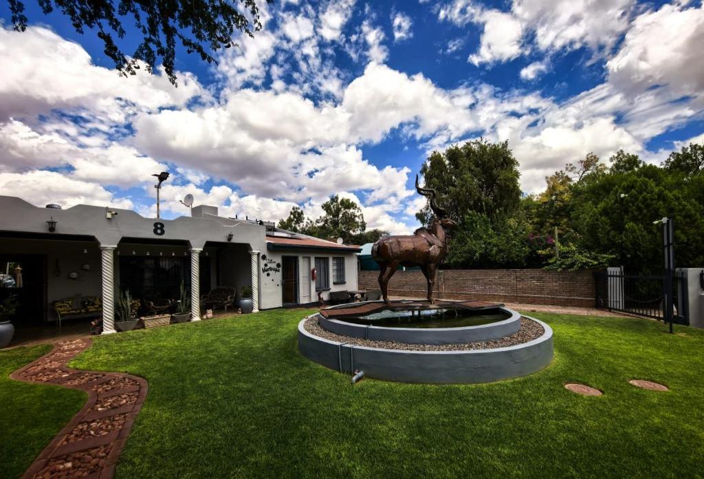 a statue of a horse on a fountain in a yard at Martinique Guesthouse in Kathu