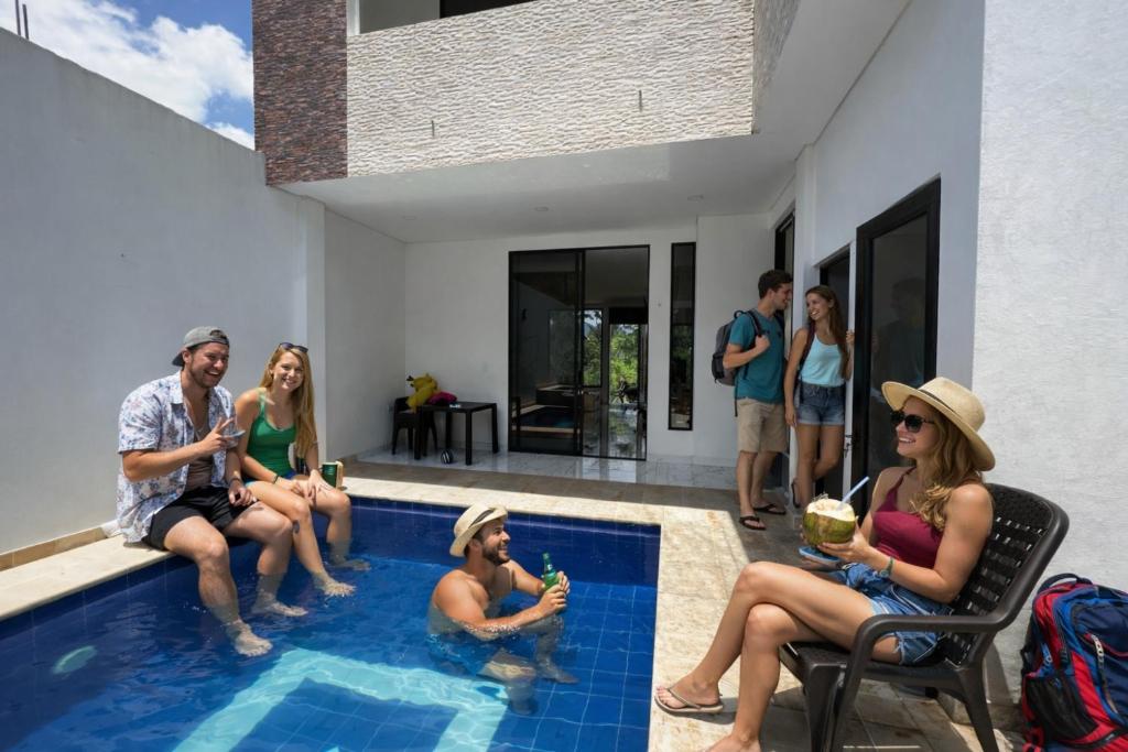 a group of people sitting around a swimming pool at Imperial Emerald House in Muzo
