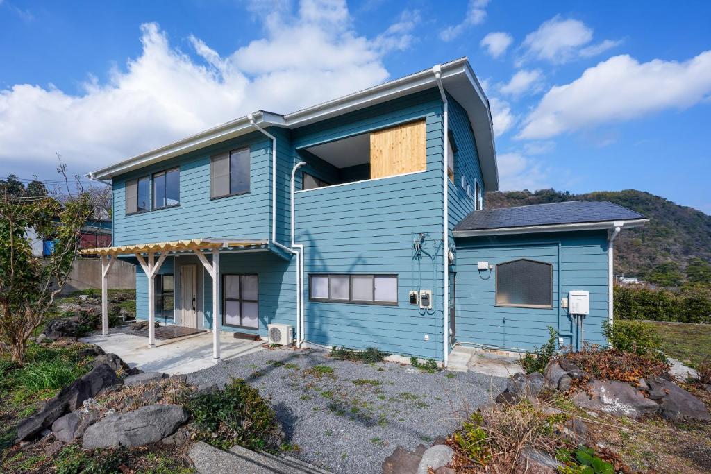 a blue house on top of a hill at Umi no SOBA 伊豆 - BBQ & Sauna in Ito