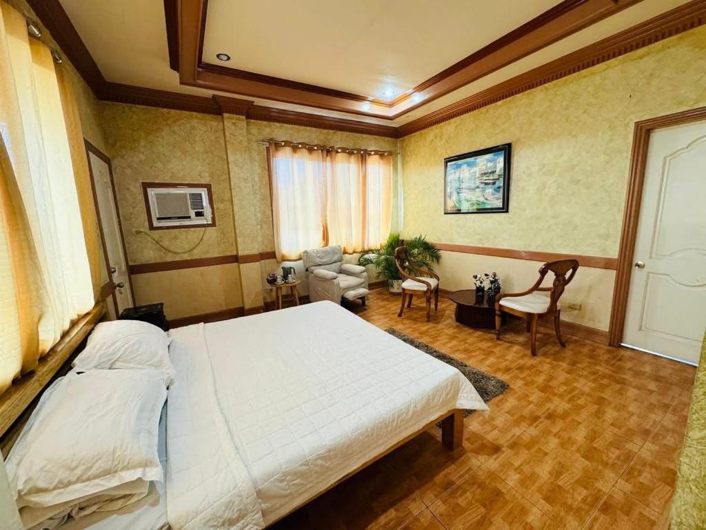 a bedroom with a large bed and a living room at Samaravilla in Tagbilaran City