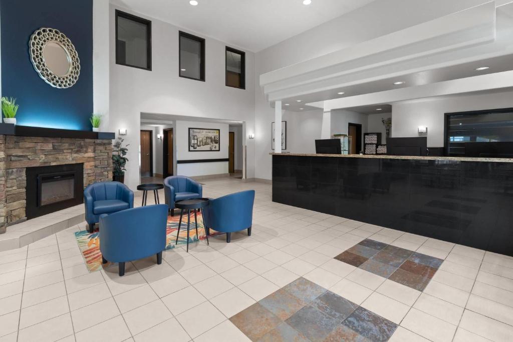 a lobby with blue chairs and a fireplace at Super 8 by Wyndham Quebec City in Quebec City