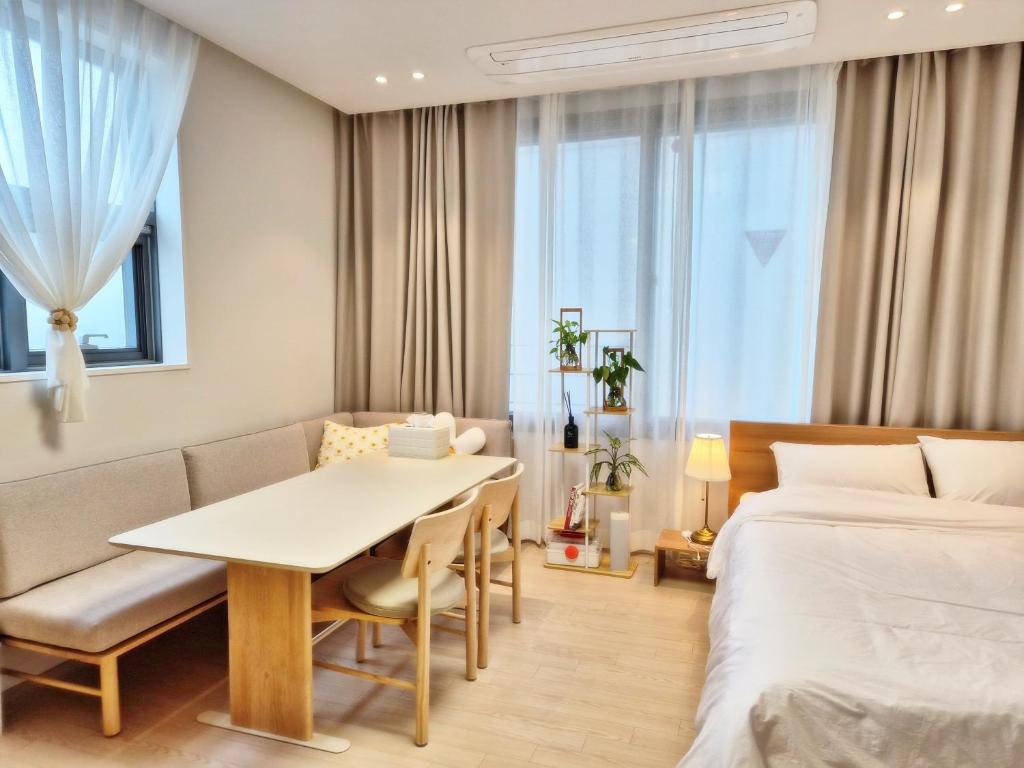 a hotel room with a bed and a table and chairs at Cozystay-Beomeo in Hyomoktong-Ilgu