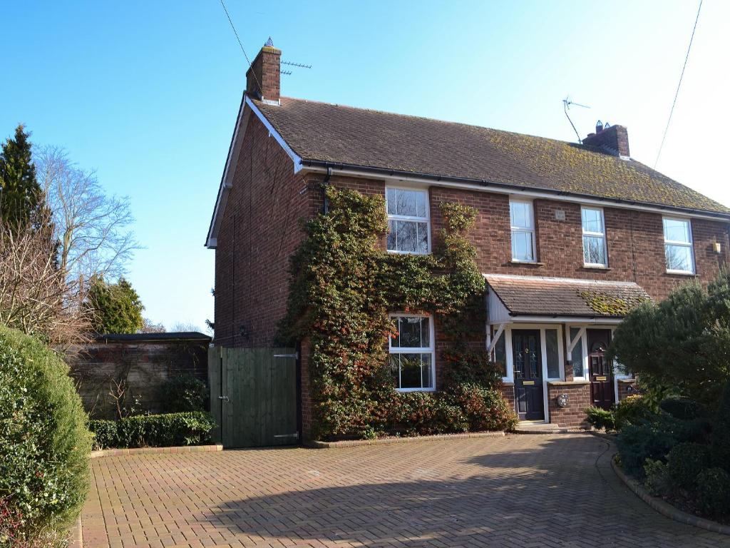 a red brick house with ivy growing on it at Pam's Plaice in Offord Cluny