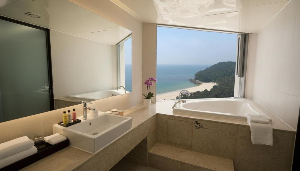 a bathroom with a tub and a sink and a window at Kwangsu Hotel Haeundae in Busan