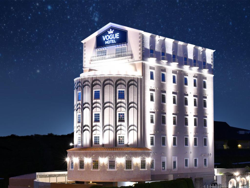 a white building with a sign on top of it at ホテル ヴォーグ in Kuwana