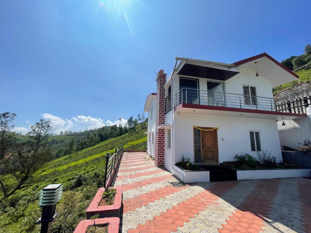 a white house with a staircase leading up to it at IndivaStays - Moon Stone Villa in Ooty
