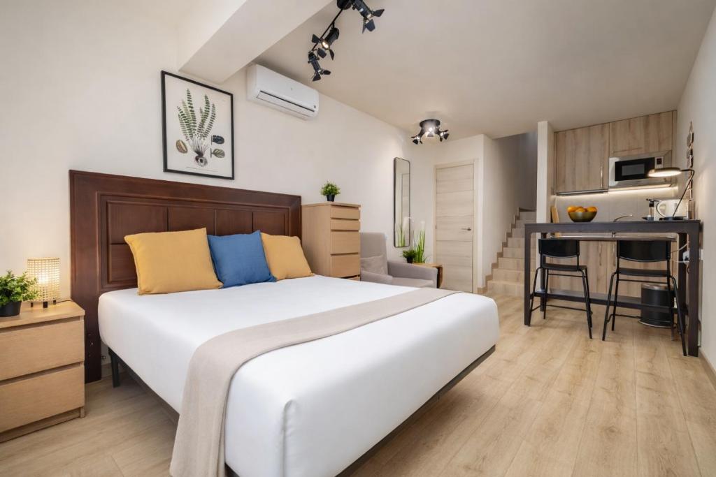 a bedroom with a large white bed and a desk at Beachfront Design LUX Studio Apartment in Estepona
